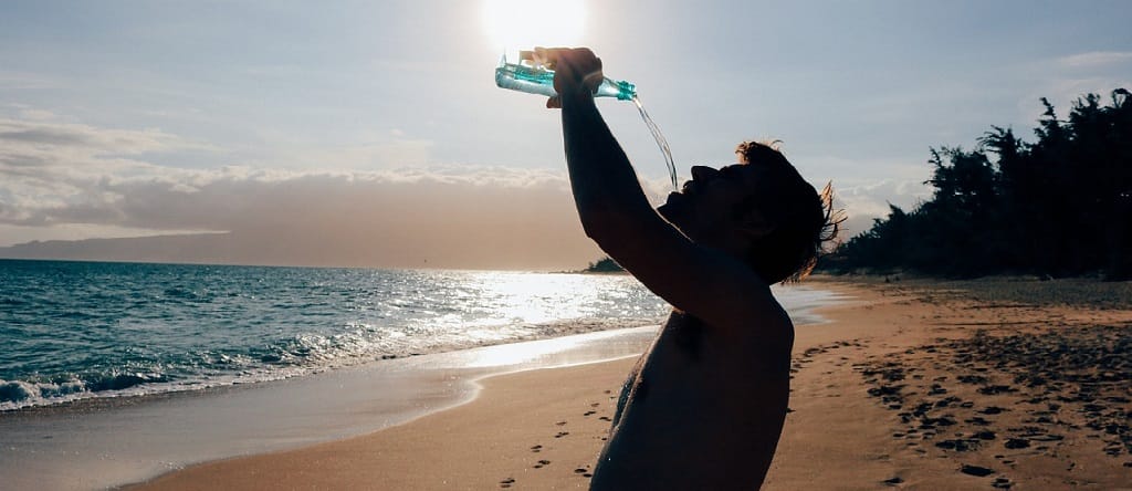 man at the seashore drinking water