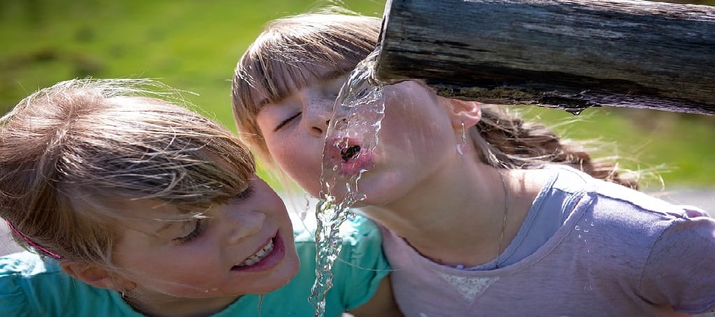 two kids drinking water